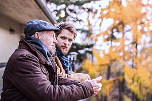 an elderly man speaking with his son about the cash surrender value of his life insurance policy